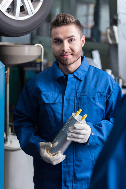 Positive man holding oil filter - Photo, image
