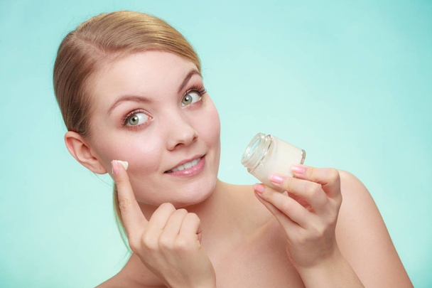 woman applying cream on her skin face. - Zdjęcie, obraz
