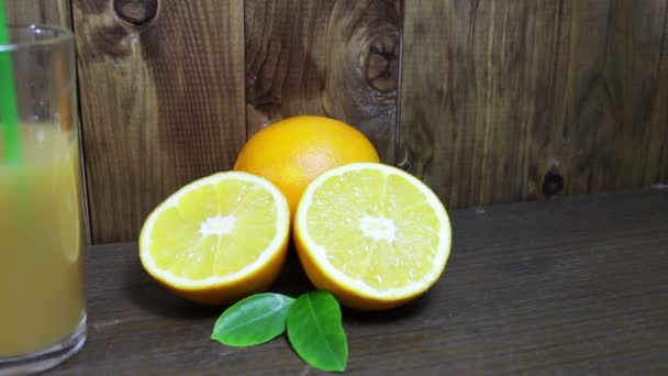 Narancslé egy pohár és friss gyümölcsöket a fa háttér - Felvétel, videó