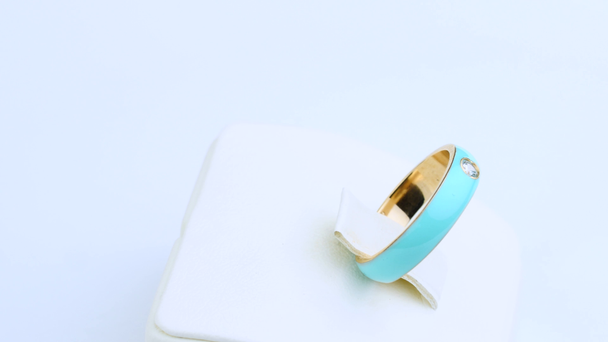 anillo de oro con joyas color turquesa sobre fondo blanco
 - Metraje, vídeo
