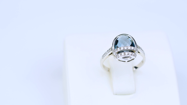 platinový prsten s modrým diamantem na bílém pozadí - Záběry, video