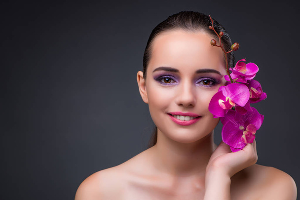 Mooie jongedame met orchideebloem - Foto, afbeelding