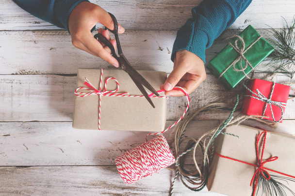 Руки девушки упаковывают подарок на Рождество
 - Фото, изображение