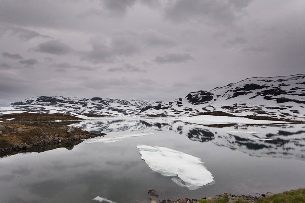 Malownicze góry Norwegii z zamarzniętym jeziorze. - Zdjęcie, obraz