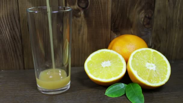Orangensaft im Glas und frisches Obst auf Holzgrund - Filmmaterial, Video