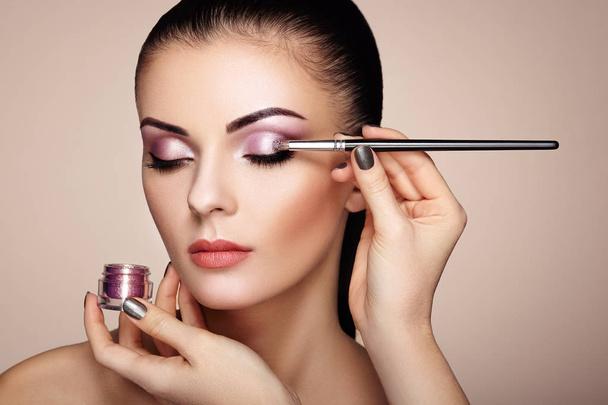 Makeup artist applies eye shadow - Foto, afbeelding