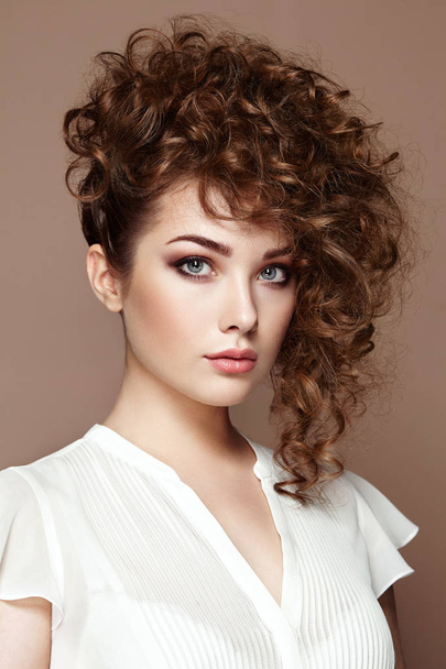 Brunette woman with curly and shiny hair - Fotó, kép