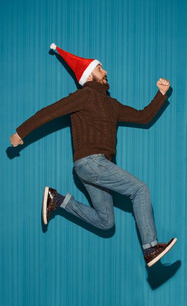 The running christmas man wearing a santa hat - Zdjęcie, obraz