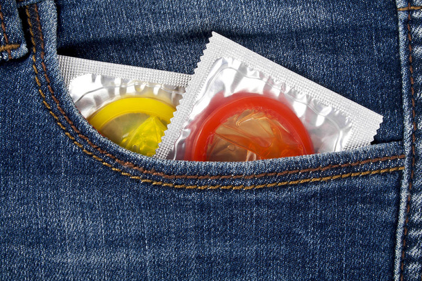 Colored condoms in a blue jeans pocket - Zdjęcie, obraz