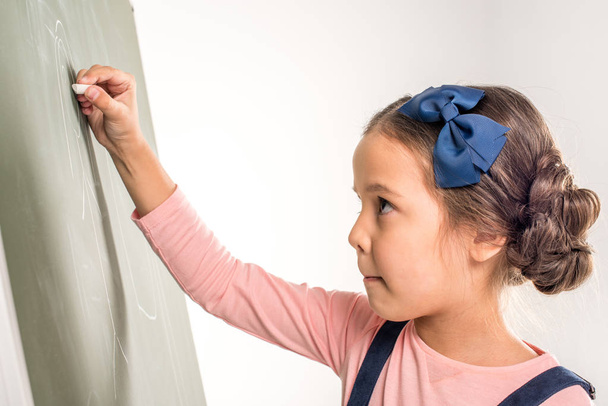 Schoolgirl drawing on blackboard - Foto, Imagem