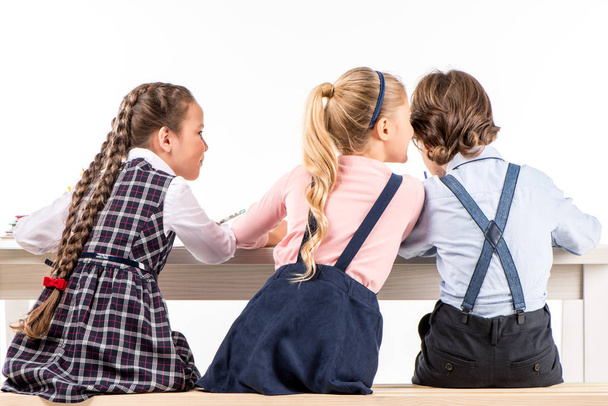 Schoolchildren sitting at desk and talking - Photo, image