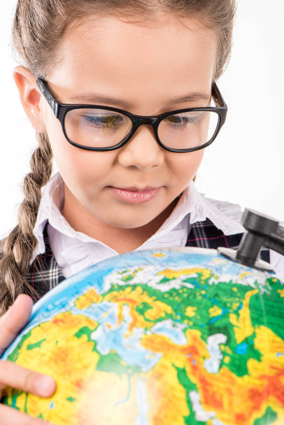 Schoolgirl looking at globe - Фото, изображение