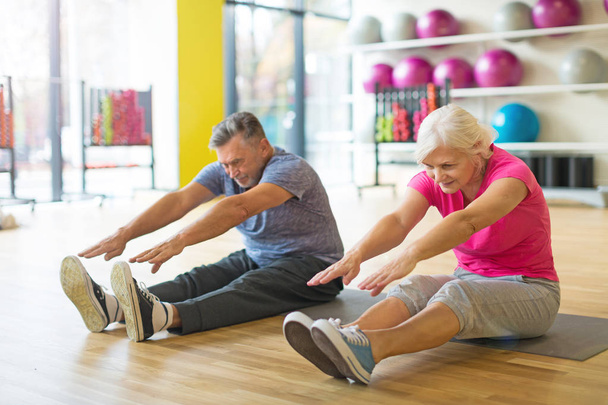 Senior couple exercising in gym - Foto, afbeelding