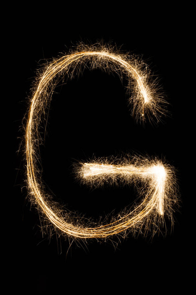 Lettre anglaise G de l'alphabet sparklers sur fond noir
. - Photo, image