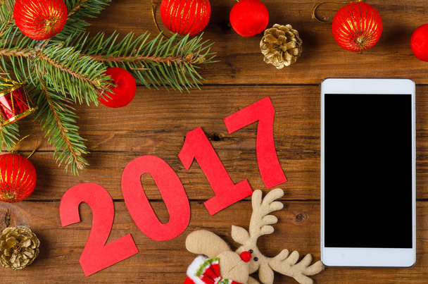 Smartphone y decoración de Navidad en una mesa de madera
. - Foto, Imagen