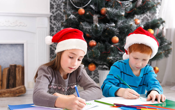 Παιδιά που γράφουν γράμμα στον Σάντα, περιμένουμε τα Χριστούγεννα - Φωτογραφία, εικόνα