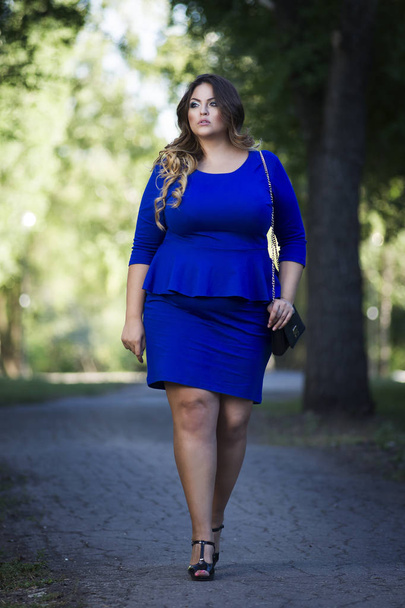 Young beautiful stylish plus size fashion model in blue dress outdoors, xxl woman on nature - Foto, imagen
