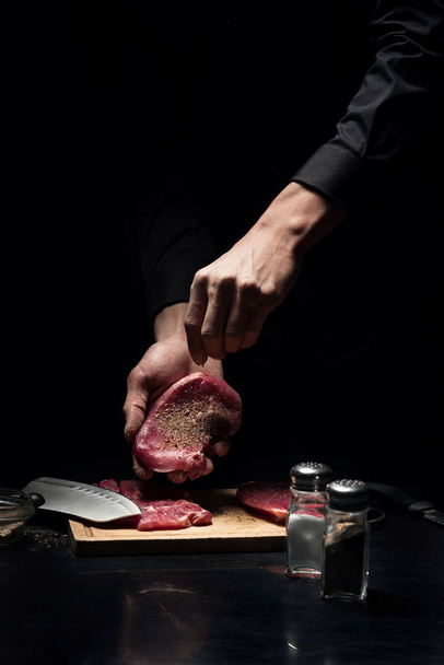 Close up of chefs hands spicing the meat - Fotoğraf, Görsel