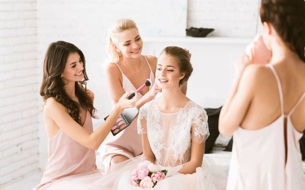 Cheerful bridesmaids preparing the young bride to the wedding ceremony - Foto, Imagem