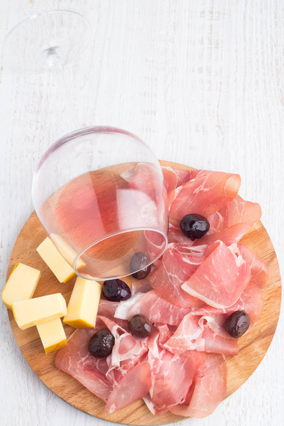 carnes curadas, azeitonas e queijo sobre fundo branco
 - Foto, Imagem