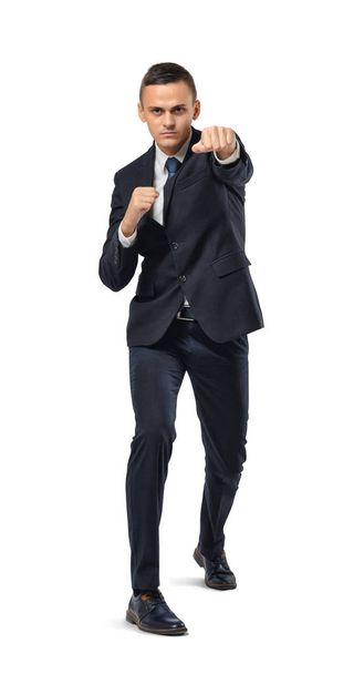 Businessman looking directly into camera in boxing pose isolated on the white background. - Foto, Imagem
