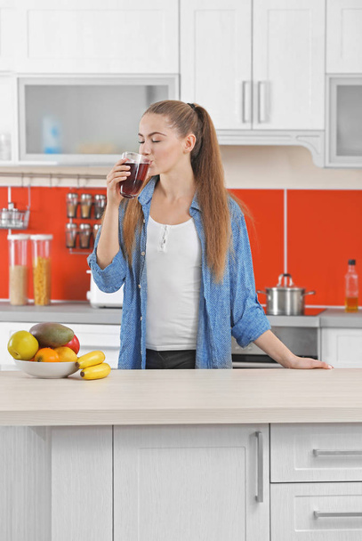 woman  in kitchen drinking juice - Φωτογραφία, εικόνα