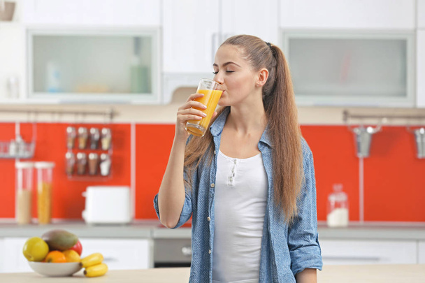  woman  in kitchen drinking juice - Photo, image