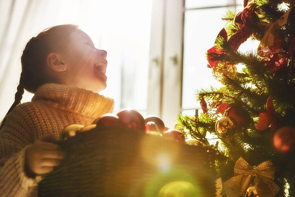 girl is decorating the Christmas tree - Valokuva, kuva