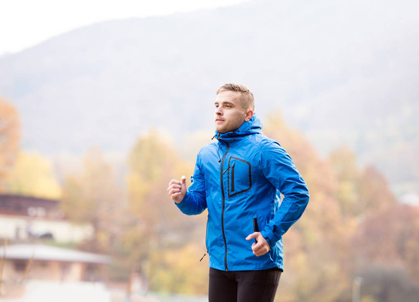 Young athlete in park running in colorful autumn nature - Zdjęcie, obraz