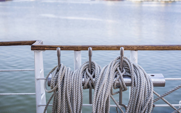 Close-up van opgerolde touw op het dek van een schip in de zomer - Foto, afbeelding