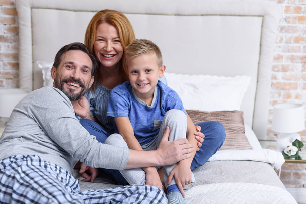 Family sitting together on bed - Valokuva, kuva