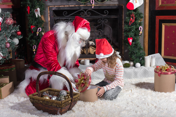 Santa Claus and cute girl getting ready for Christmas. - Фото, изображение
