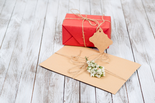 Greeting letter and gift box with tag on wooden background. - Фото, зображення