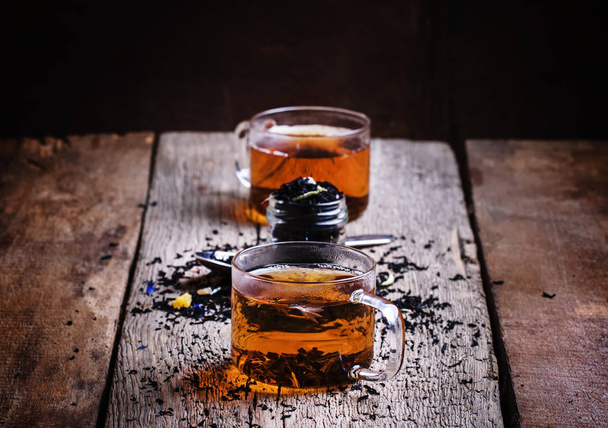 Zwarte thee met bloemen Korenbloem en gedroogde vruchten in glazen bekers   - Foto, afbeelding