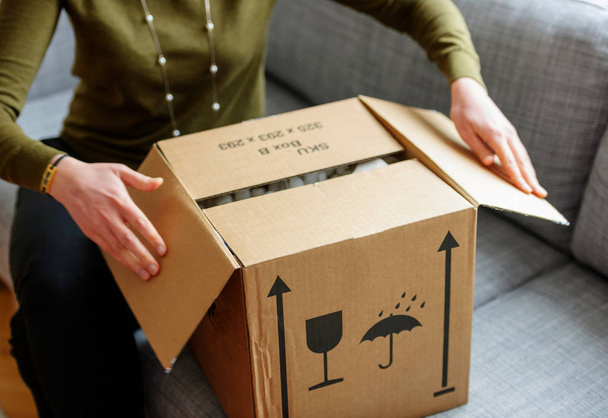 Mujer desembalaje unboxing caja de cartón con almohadillas de espuma protectora en el interior después de comprar pedidos en línea a través de Internet un regalo bueno
 - Foto, Imagen