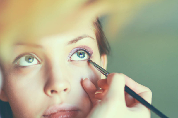 Make up artist doing professional makeup of young woman - Фото, изображение