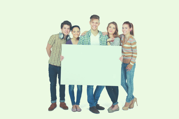 Ryhmä nuoria ystäviä, joilla on tyhjä lauta, eristetty valkoisella taustalla - Valokuva, kuva