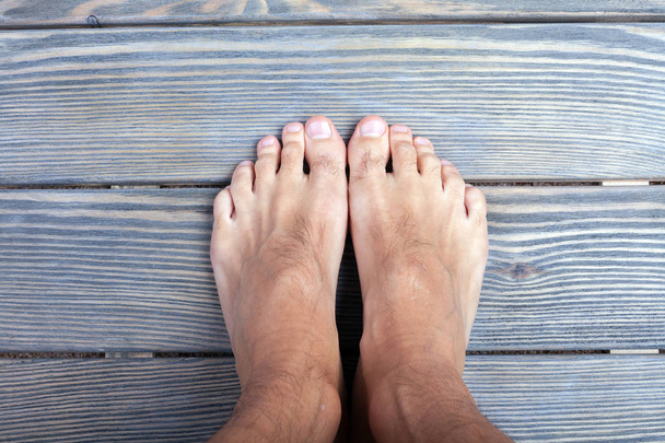 male feet on wooden background. - Photo, image