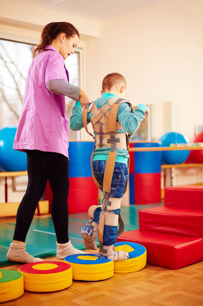 cute kid having physical musculoskeletal therapy in rehabilitation center - Foto, Imagen