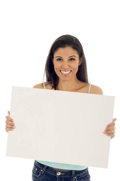young attractive and happy hispanic woman holding blank billboard with copy space - 写真・画像