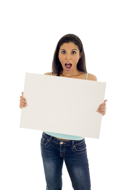 junge attraktive und glückliche hispanische Frau hält leere Plakatwand mit Kopierraum - Foto, Bild