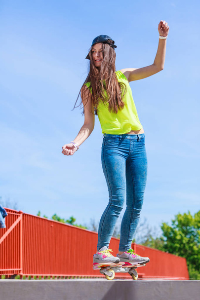 Teen girl skater riding skateboard on street. - Foto, imagen