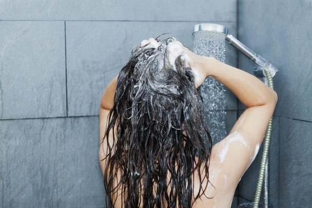 Woman washing her hair - 写真・画像