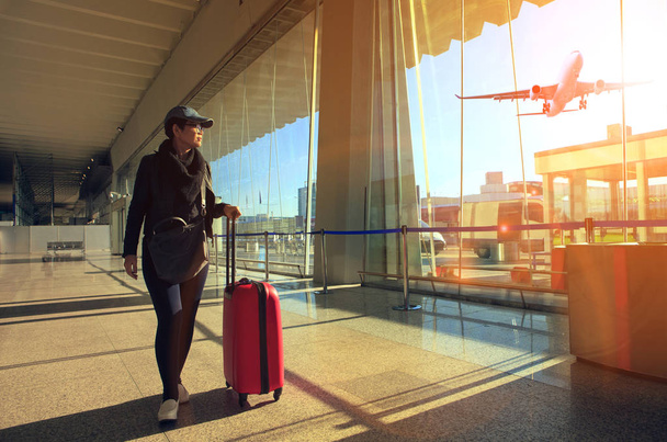 ταξιδεύουν γυναίκα και περπάτημα στο τερματικό σταθμό του αεροδρομίου και αέρα των αποσκευών  - Φωτογραφία, εικόνα