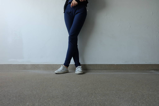 Moda mujer joven en pantalones vaqueros azules y zapatillas blancas en las calles
  - Foto, Imagen