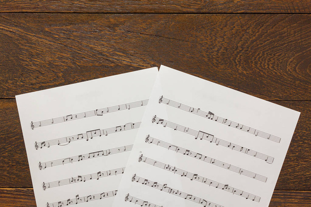 Papel de nota de música de Navidad vista superior sobre fondo de mesa de madera
. - Foto, Imagen