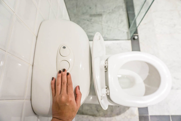 save the enviroment by flush the toilet with human hand - Valokuva, kuva