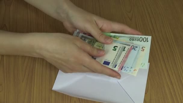 Nő kezében számít a pénz euro-bankjegyek, és tegye a borítékot. 4k - Felvétel, videó
