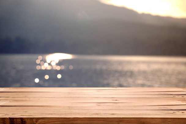 fa asztal homályos tenger és a nap - Fotó, kép