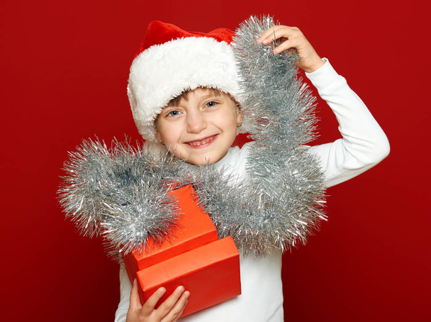 girl child portrait with gift box on red, christmas holiday concept - Foto, imagen